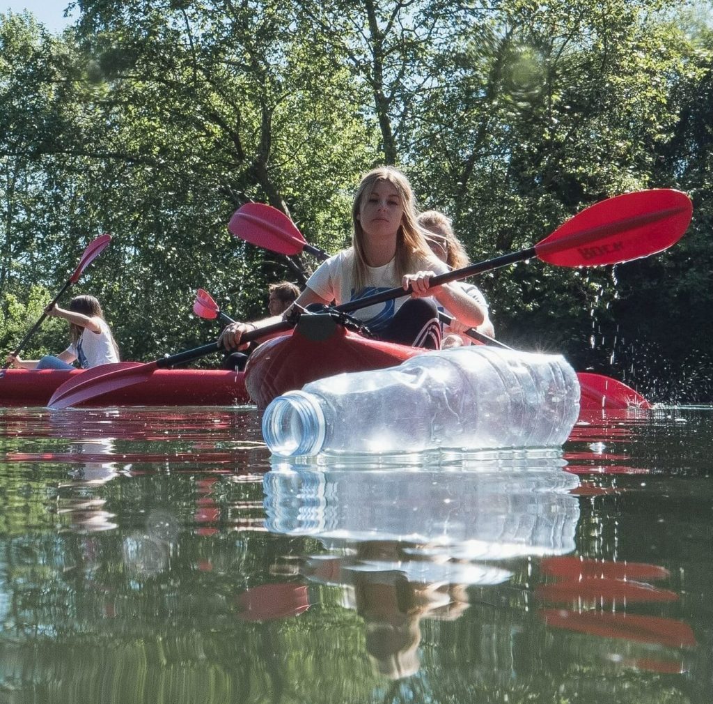 eine Kajakfahrt in einem mit Plastik verschmutzten Fluss